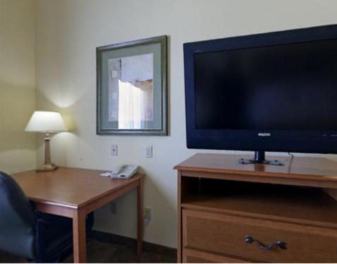 a flat screen tv sitting on top of a wooden dresser at Holiday Inn Express Hotel & Suites Zapata by IHG in Zapata