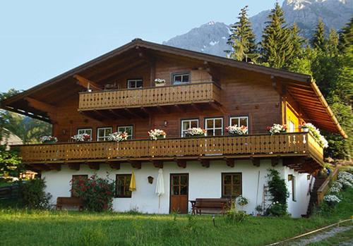 Casa de madera con balcón en la parte superior. en Haus Berghild, en Ramsau am Dachstein