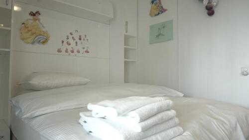 Una cama blanca con toallas encima. en Home by Livingdowntown en Zug