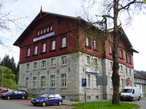a large building with cars parked in front of it at Pension na hranici in Železná Ruda