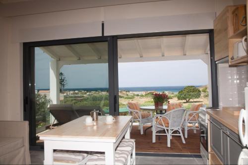 a kitchen and dining room with a view of the ocean at Artemis Village Apartments & Studios in Stavros