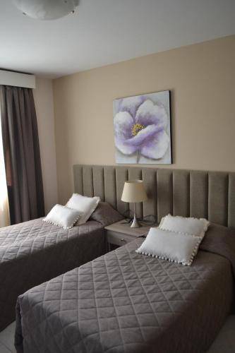 a hotel room with two beds and a painting on the wall at Marianna Hotel Apartments in Limassol