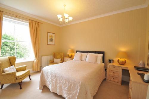 a bedroom with a bed and a desk and a chair at Marton Grange Country House in Bridlington