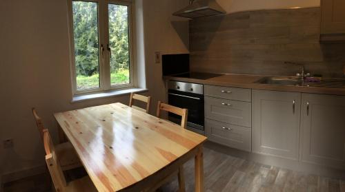 cocina con mesa de madera y fregadero en Carrickamore Cottage en Boyle