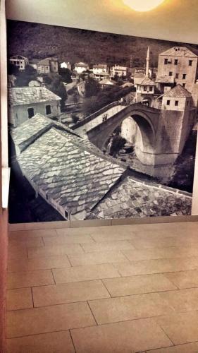 a wall with a painting of a bridge at Motel Aura in Mostar