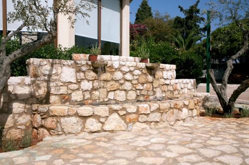 a stone retaining wall in front of a building at Artemis Village Apartments & Studios in Stavros