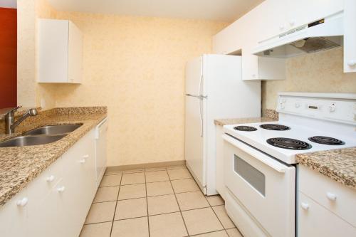 a kitchen with white appliances and a sink at Holiday Inn Hotel & Suites Osoyoos by IHG in Osoyoos