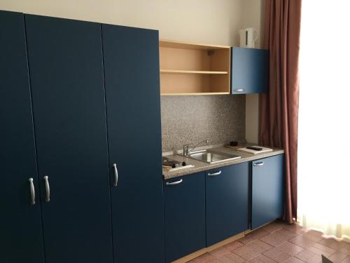 una cucina con armadi blu e lavandino di Residence Wieland a Torri del Benaco