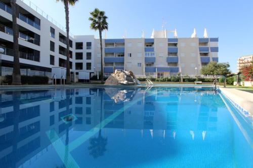 a large swimming pool in front of a building at Apartament Pinada Beach in La Mata