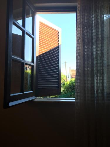 an open window with a view of a building at Bela Vita, Porto Covo in Porto Covo