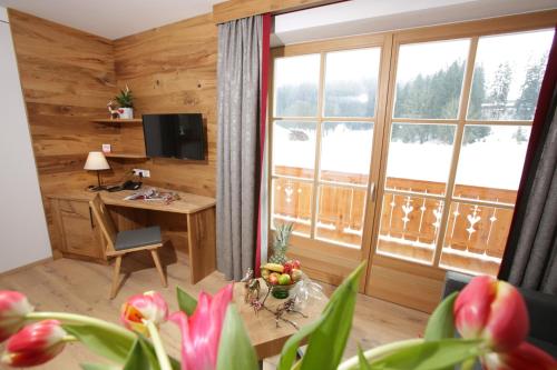 sala de estar con escritorio y ventana grande en Postgasthof, Hotel Rote-Wand, en Bayrischzell