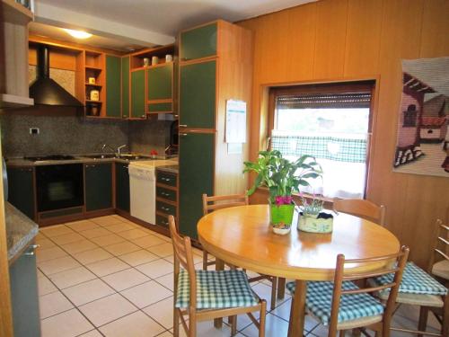 a kitchen with a wooden table and chairs in a kitchen at Casa Caterina in Fiera di Primiero