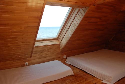 a attic room with two beds and a window at Peipsi rannamaja in Nina
