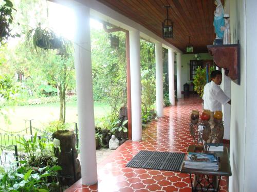 a man standing on the porch of a house at Hotel Casa Duranta in Cobán