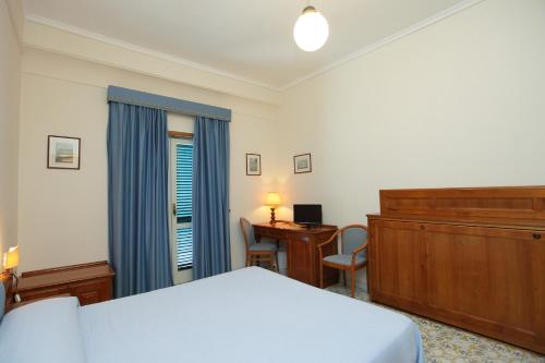 1 dormitorio con 1 cama, vestidor y escritorio en Hotel Mega Mare, en Vico Equense