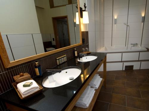 a bathroom with two sinks and a large mirror at Eriksberg Hotel & Nature Reserve in Trensum