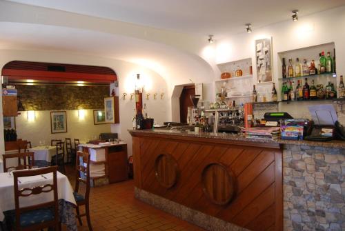 a bar in a restaurant with a counter and a table at Appartamenti Corneliani in Sirmione