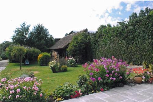 einen Garten mit Blumen vor einem Haus in der Unterkunft Chambre d'hôte Courtoux in Saint-Denis-sur-Sarthon