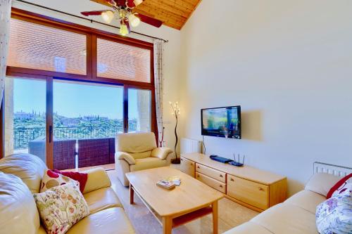 a living room with a couch and a tv at 4 bedroom Villa Helidoni with private infinity pool, Aphrodite Hills Resort in Kouklia