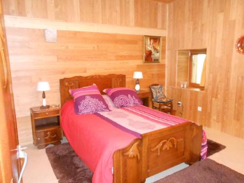 Gite du Cret في Hotonnes: غرفة نوم مع سرير بملاءات وردية ومخدات أرجوانية