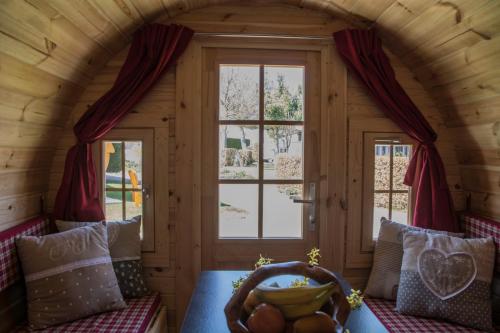 a room with a window and a couch with a bowl of fruit at Camping-Erbenwald in Neubulach
