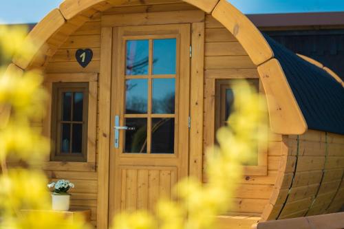 a wooden shed with a door and a window at Camping-Erbenwald in Neubulach