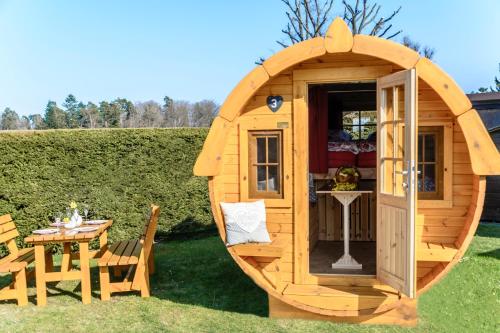 Casa hobbit de madera con mesa y sillas en Camping-Erbenwald, en Neubulach