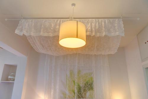 a light hanging from a ceiling with a curtain at Ethrion in Ermoupoli