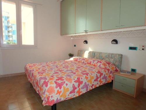 een slaapkamer met een bed met een kleurrijke sprei bij Esperia 23 in Lido di Pomposa