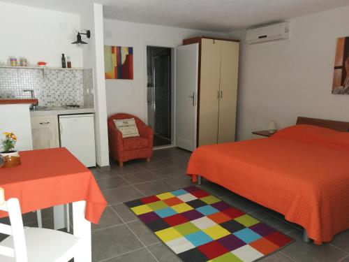 a bedroom with two beds and a table and a kitchen at Apartments Priko in Stari Grad