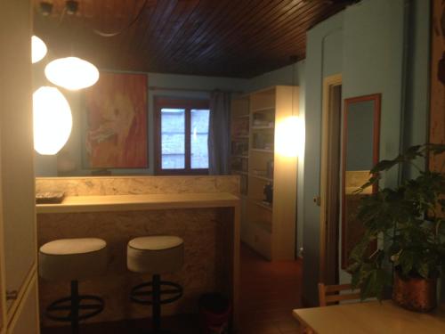 una cucina con due sgabelli e un bancone con luci di Mood Villa Glori a Pavia