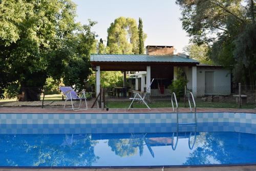 a house with a swimming pool with a table and chairs at La Casa de Don Pepe in Villa Las Rosas