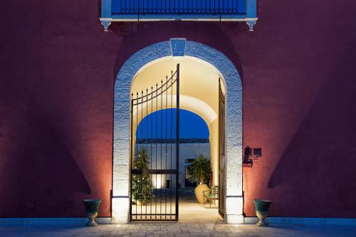 an entrance to a red building with an iron gate at Masseria Della Volpe in Casale Modica
