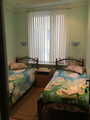 um quarto com 2 camas e uma janela em Zenith Guest House em Kislovodsk