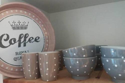 a group of cups sitting on a shelf next to a plate at Bastide Provençale Les Mûriers d'Engaspaty in Seillans