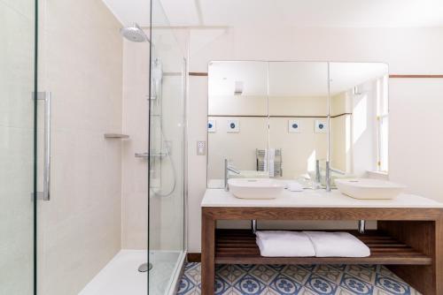 a bathroom with two sinks and a mirror at The Perle Oban Hotel & Spa in Oban