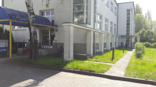 a white building with a blue awning next to a sidewalk at Amarillo Hotel Velten in Velten