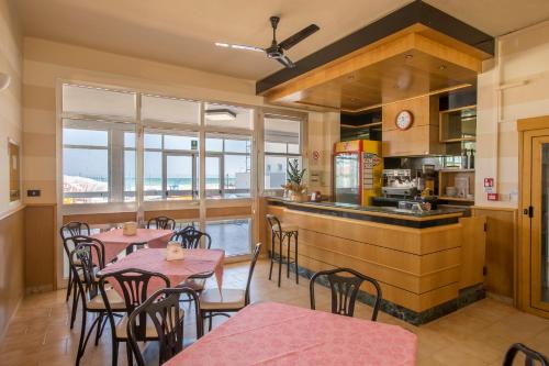 a restaurant with tables and chairs and a kitchen at Villa San Francesco in Misano Adriatico