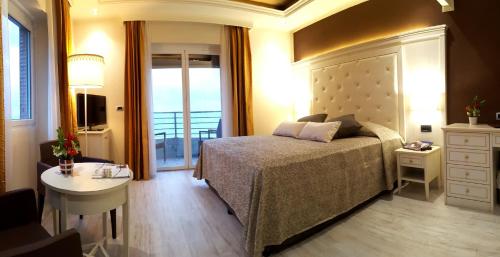 a bedroom with a bed and a table and a window at Hotel Regina in Alassio