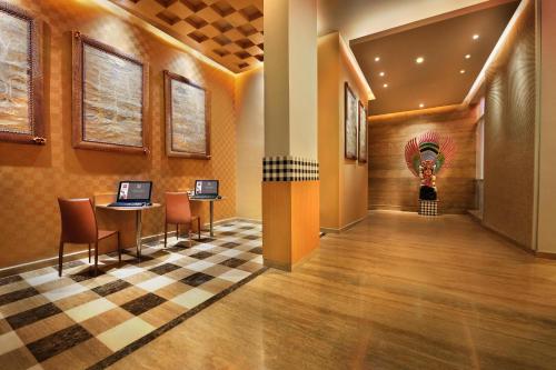 a lobby of a hotel with a table and chairs at Ibis Bali Kuta in Kuta
