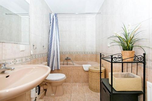 La salle de bains est pourvue d'un lavabo, de toilettes et d'une baignoire. dans l'établissement Słoneczny Apartament Sopot, à Sopot