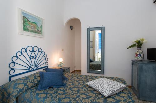 a bedroom with a bed and a mirror at Hotel Poseidon in Lipari
