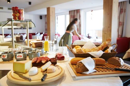 a table topped with cheese and bread on top at Hotel Zontaja Superior in Galtür