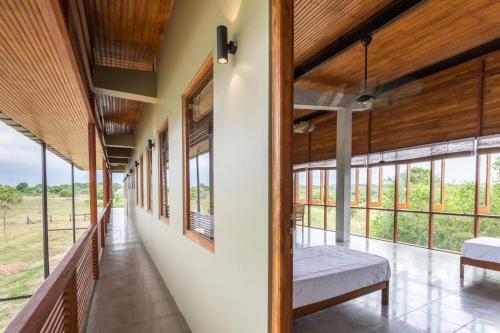 a hallway of a house with windows and a bench at Tree Tops Yala in Yala