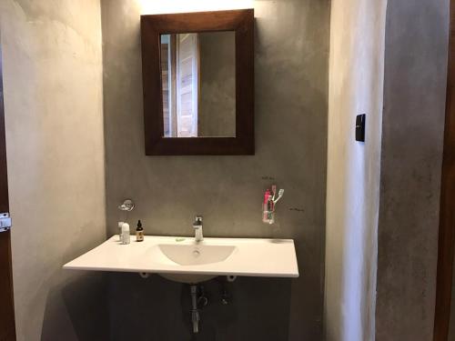 ein Badezimmer mit einem weißen Waschbecken und einem Spiegel in der Unterkunft Tree Tops Yala in Yala