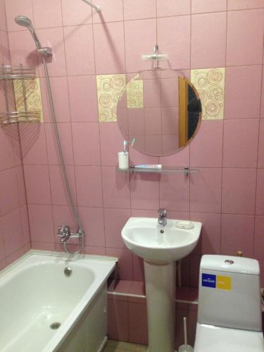 a pink bathroom with a sink and a toilet at Apartment Na Ryabinina in Yekaterinburg