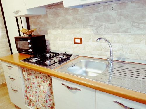 a kitchen with a sink and a stove at Hostel Josef in Palermo