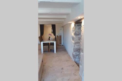 a hallway with a stone wall and a table at Bastide Provençale Les Mûriers d'Engaspaty in Seillans