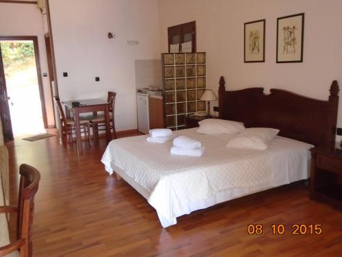 a bedroom with a bed with towels on it at Hotel Aglaida Apartments in Tsagarada