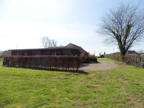 uma casa com uma sebe em frente a um campo em Au fil de l'eau em Conchy-sur-Canche
